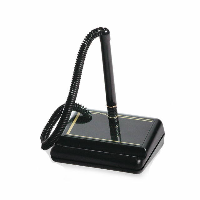 Stiloforo composto da penna a sfera (inchiostro nero) e portapenna rettangolare in plastica. Penna collegata alla base tramite una molla a spirale. Base di colore nero (9x7 cm) con rigatura in oro. Ricaricabile con refill cod. 81866.